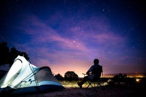 Man sitting in camp site gazing at the stars