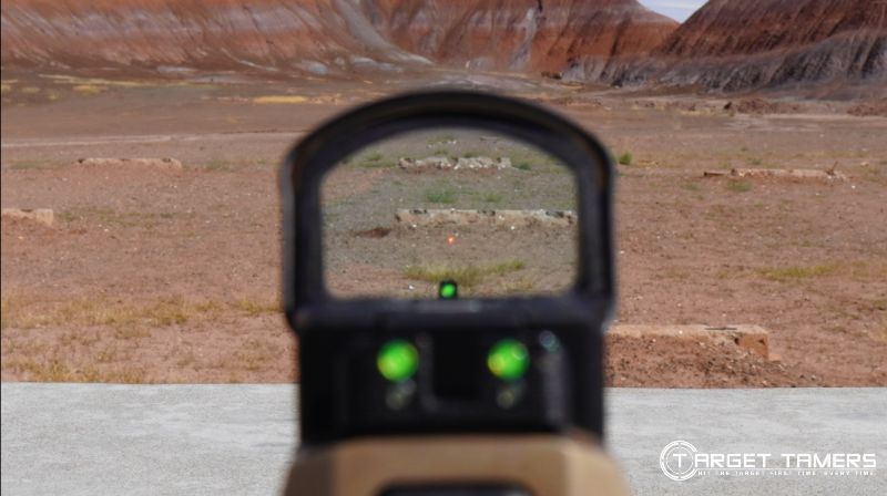 Looking through iron sights and red dot sight on a handgun